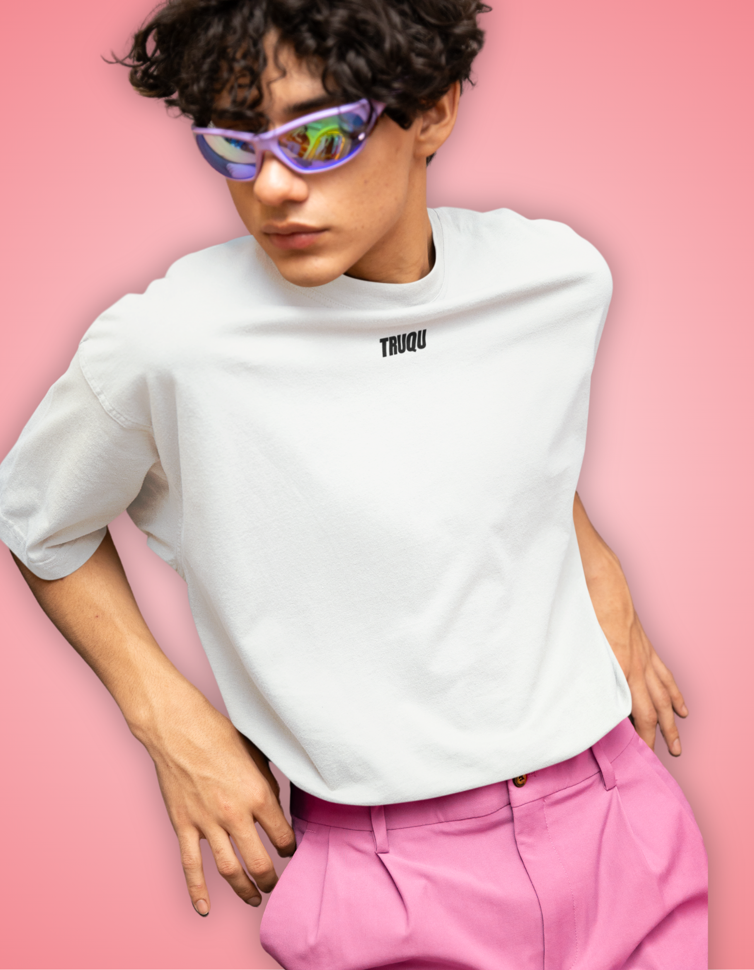 Person wearing a white t-shirt with 'TRUQU' logo and pink pants against a pink background